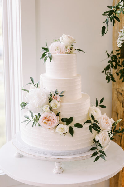 Lush floral table arrangement in soft pastel tones, perfect for an elegant wedding reception, designed by Leigh Florist.