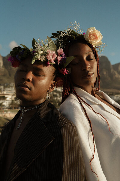 bride and groom leaning heads against each other, wearing flower crowns at their africa elopement