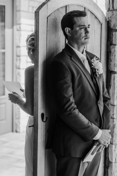 black and white photo of bride and groom reading letters