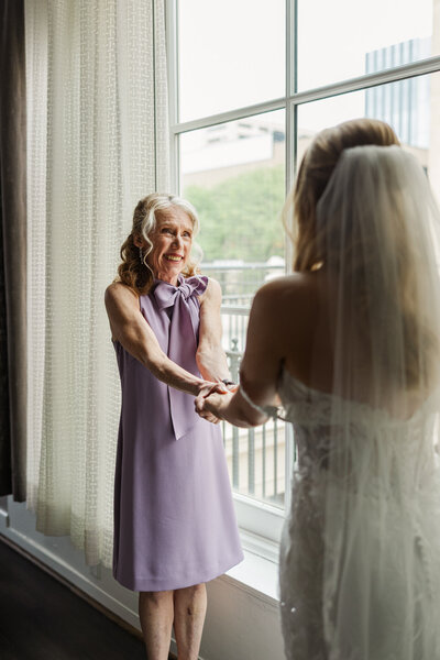 A bride & mother of the bride share an emotional moment while getting dressed. Photo by Claire Katan at The Magnolia Hotel.