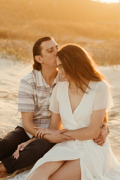 Haley and Zach sitting in the sand at Padre Balli Park