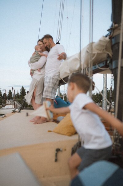 family of four on boat holding newborn baby