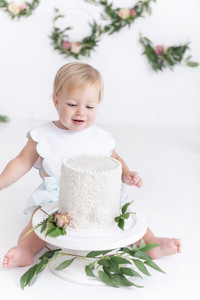 toddler girl wearing boutique dress for cake smash