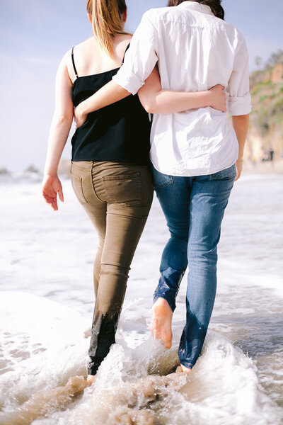 Two women embrace on El Matador Beach in  Malibu california