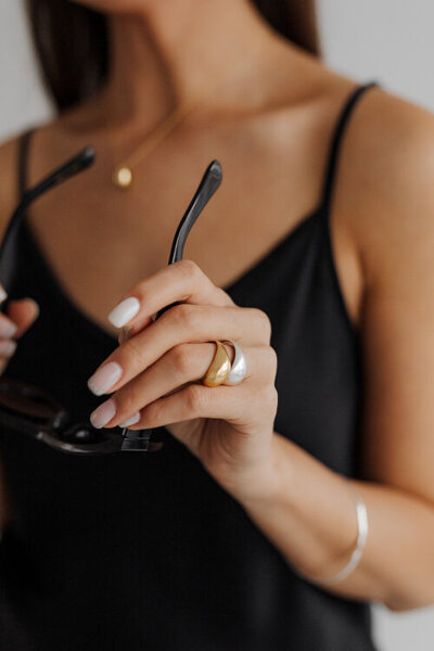 detail rukou ženy držící sluneční černé brýle