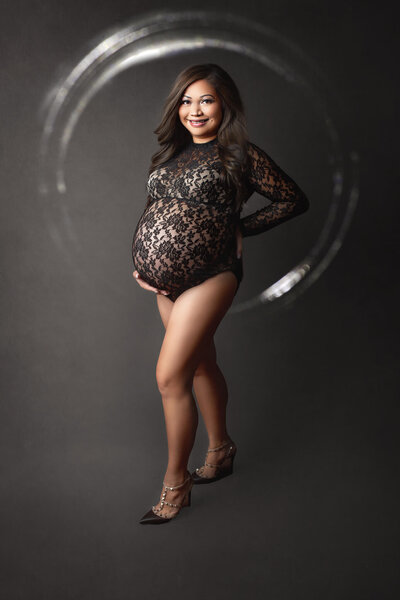 pregnant woman in black lace bodysuit and black high heels posed for maternity photos in Hamilton, ON
