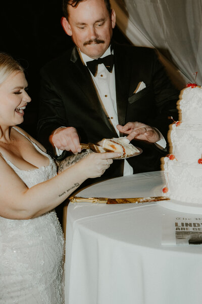 Bride and groom cutting their wedding cake at a reception designed by Southern California wedding planner Beyond the Event, captured by Kellie Jane Photography.