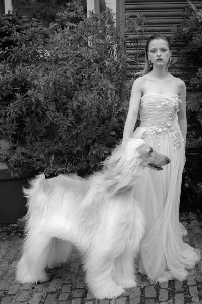 Fine art wedding photograph in monochrome of a bride standing sipping champagne