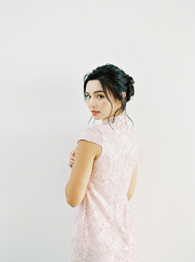 Model posing in pink qipao
