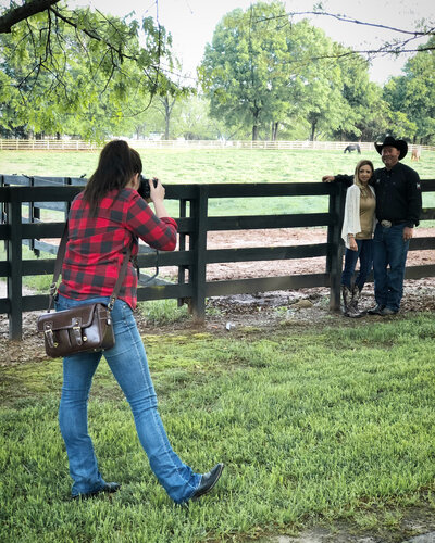 Hiliary taking photos of engaged couple Jason and Jamie English in front of a horse pasture before their wedding.