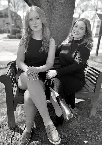 black and white image of allison and amanda on a park bench for the about page