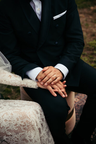 A close-up of hands interlocked, symbolizing the deep and meaningful connection between the couple as they share a moment of unity and love