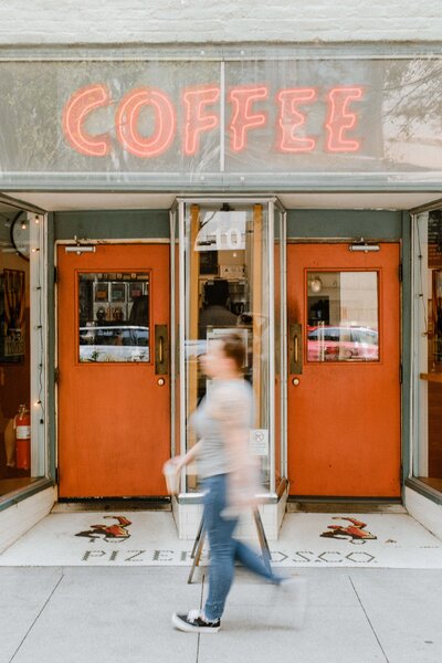 woman walking in front of coffee shop