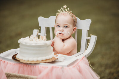 One year old with cake on face during cake smash session in Brentwood, CA