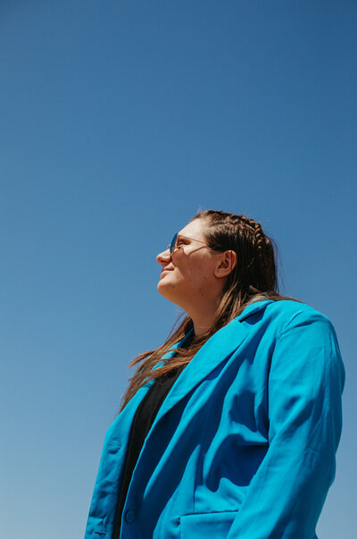 Girl in a blue jacket looking at the sky.
