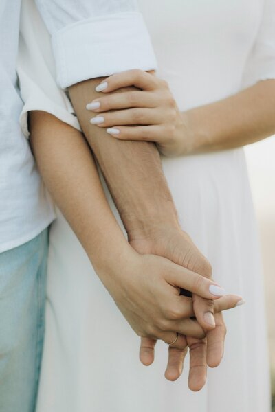Man and woman holding each others arms and hands 