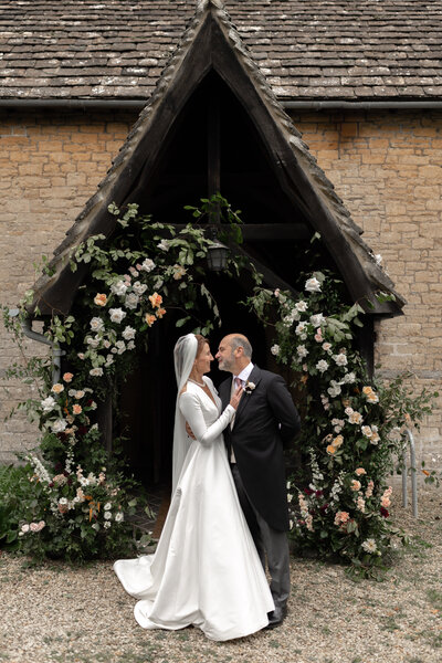 Couple portrait with floral arch by Flowers by Passion