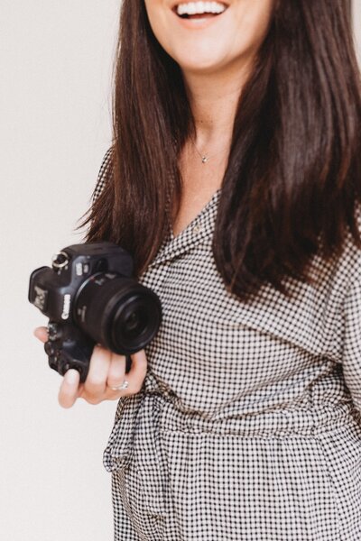 woman putting camera lenses into camera bag