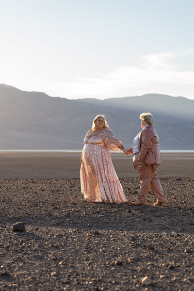 A couple holding hands and walking in the desert