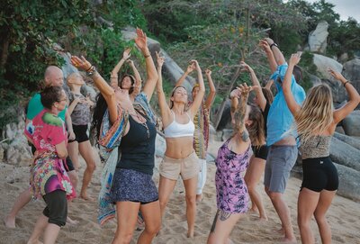 group of people dancing on the beach during jungle dance retreat