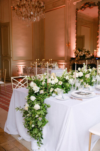 Wedding reception decoration with greenery and white florals.