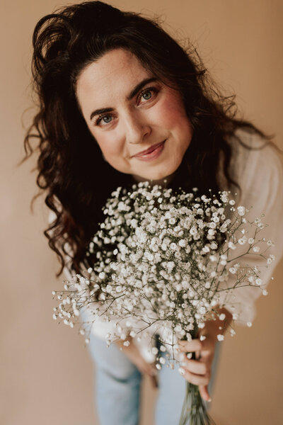 woman holding a floral bouquet by face