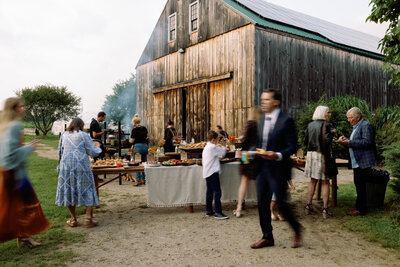 Candid outdoor cocktail hour at a barn wedding 