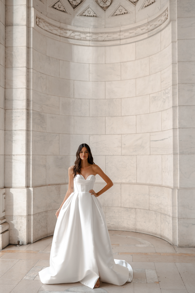black and white image bride wearing strapless satin wedding dress with long train