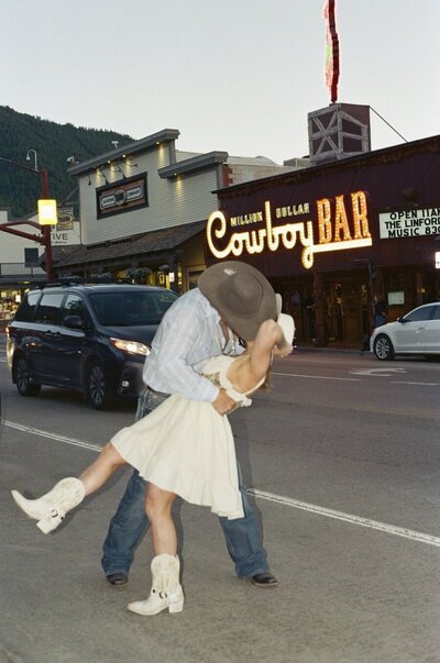 Couple kissing in front of the Million Dollar Cowboy Bar in Jackson, Wyoming