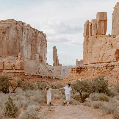 This couple did their engagement session in the canyons of Moab, Utah. Their neutral cream colored outfits paired perfectly with the orange desert tones.