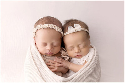 Newborn twin girls from Medina Ohio holding hands