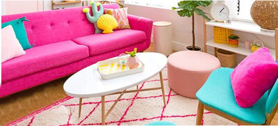 Pink couch with fun pillows and bold design