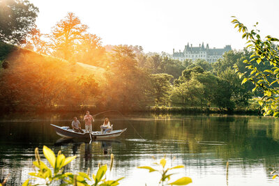 The Biltmore in Asheville, North Carolina, featuring people fishing in the pond at sunrise.