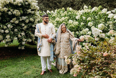 Muslim bride and groom walk through garden before their Nikkah ceremony