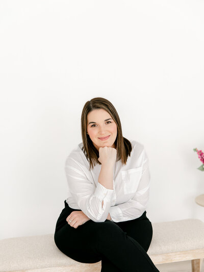 portrait of a woman sitting on a bench in studio during a headshot and branding session