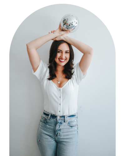 woman holding small disco ball over her head