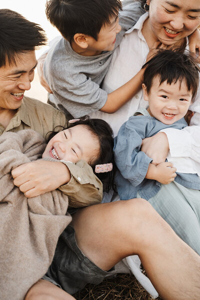 dad holding newborn with toddler
