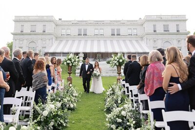 Wedding ceremony entrance with floral flanked aisle at New England outdoor estate