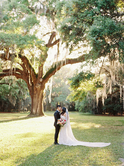 Bride and Groom walking hand in hand at Lowndes Grove in Charleston SC