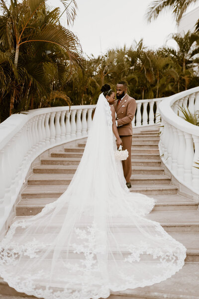 bride and groom sharing a romantic moment in a tropical country sorrounded by palms planned by sunberry travel co