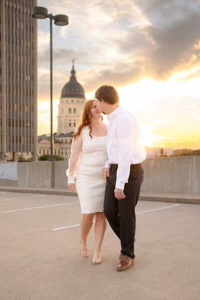 Engaged Couple laughing with Topeka Capitol in Background