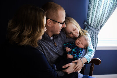 Newborn Photo taken of baby looking at the camera | Taken By Maine Photographer who photographs in places like Rangeley, Sugarloaf, Bar Harbor, and more in Maine