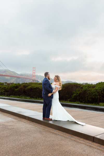Newlyweds celebrate their wedding in front of the Golden Gate Bridge in San Francisco, CA.
