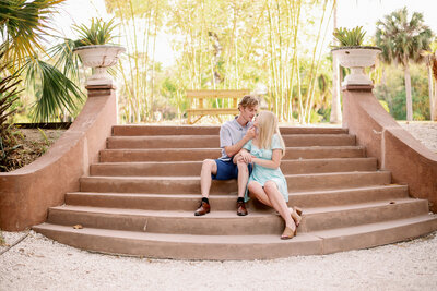 engaged couple sitting, almost kissing, on the dockside steps of Koreshan State Historic Park in Estero, FL
