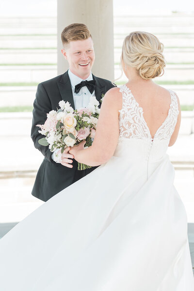 groom looking at bride with a textured low bun for the first time, Indianapolis Wedding Hair and Makeup