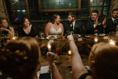 bride and groom stand up saying their vows at their ceremony in dark lighting