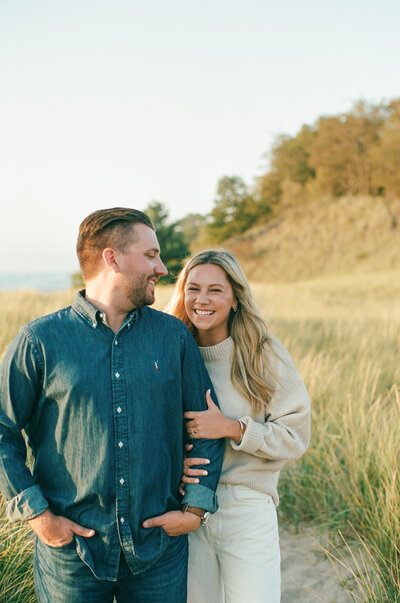 couple sitting in beach grass hugging