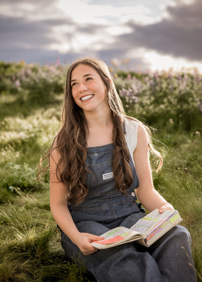 Girl reading a book in a field of wildflowers in the Columbia River Gorge.