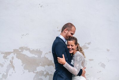 laughing & hugging wedding couple