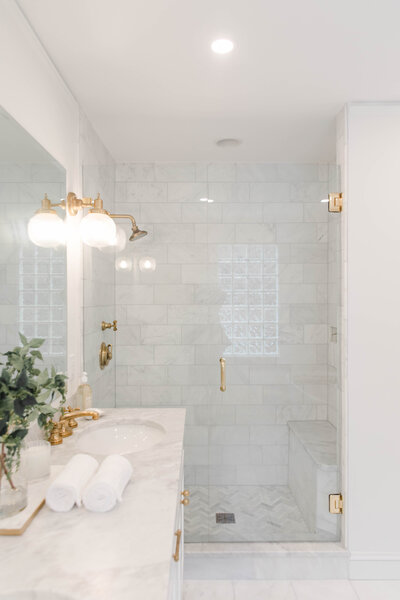 Charleston interior design portfolio by KASL Design Co. – featuring a marble bathroom with brass fixtures.